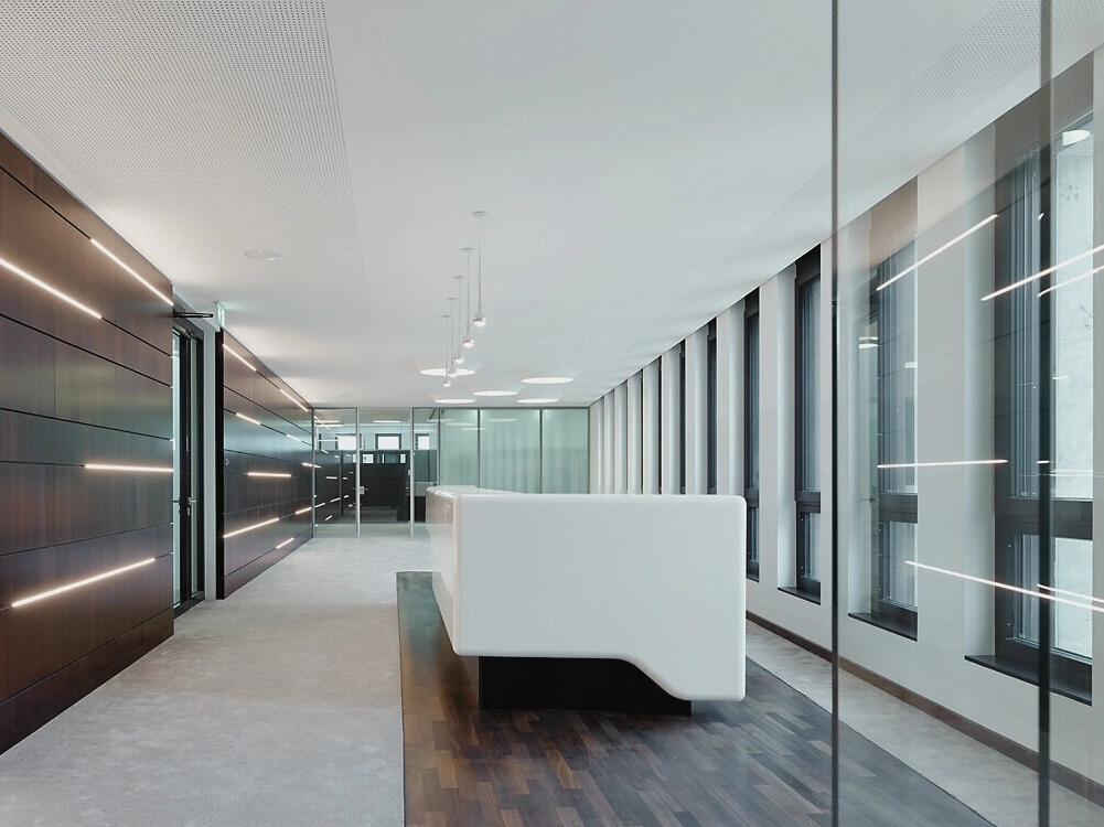 Bankhaus_Foyer Moderner Empfangsbereich mit weißen Wänden, Glasfronten und Holzwandverkleidung, ohne Personen.